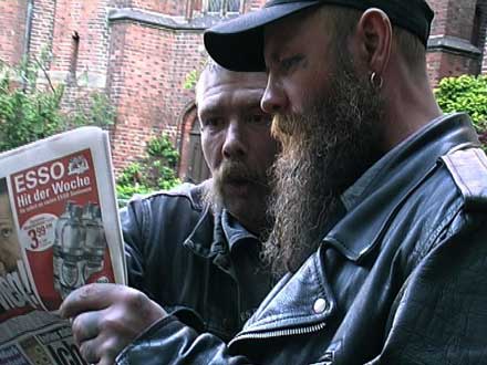 two homeless men reading newspaper